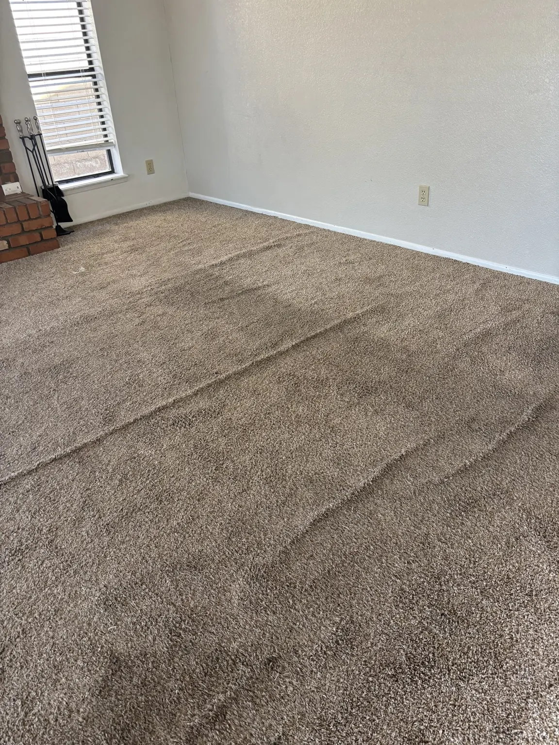 Severe wrinkles across a room before carpet restretching